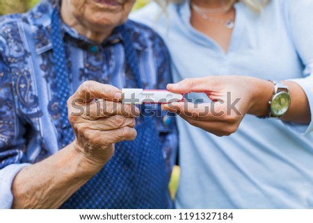Close up picture of young woman holding pregnancy test with grandmother. Great-grandchild on the way