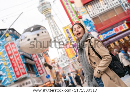 pretty female traveler standing in front of Tower Reaching Heaven. there is a puffer fish balloon in the sky