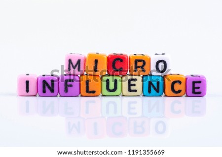 MICRO INFLUENCE word block concept on white reflection table