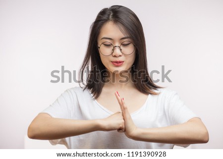 Asian female holding hands in greeting with Thai culture sign, gives warm welcome isolated on white background.