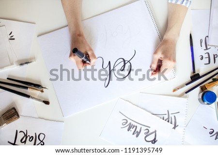 Top view of hand of girl with pen writes on paper with ink Royalty-Free Stock Photo #1191395749