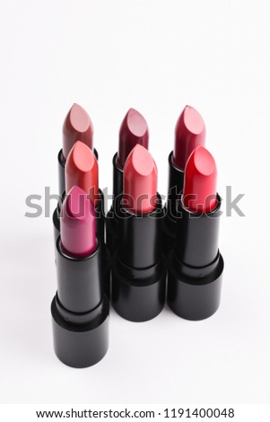 Many different lipsticks, different colors on lilac background. Space for text or design.