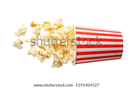 Overturned cup with delicious fresh popcorn on white background, top view