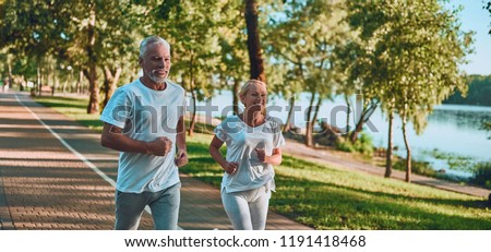 Senior couple is doing sport outdoors. Running in park in the morning. Royalty-Free Stock Photo #1191418468