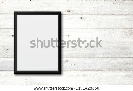 White poster or a white picture frame hanging on the white wood wall background in the room.Have space for your message.