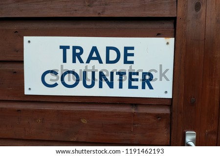 Trade Counter Sign on White Plastic Attached To Wood Panelling - Image