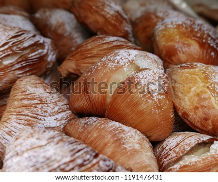 close shot of a group of Neapolitan Sfogliatelle, typical dessert covered with icing sugar