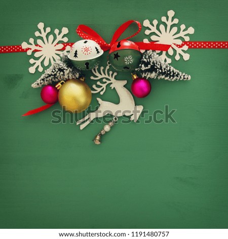 Christmas background with red silk traditional ribbon, white deer, evergreen tree and jingle bells