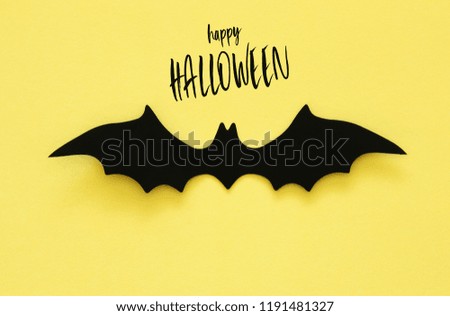 Halloween holiday concept. Black bats over yellow background. Top view, flat lay