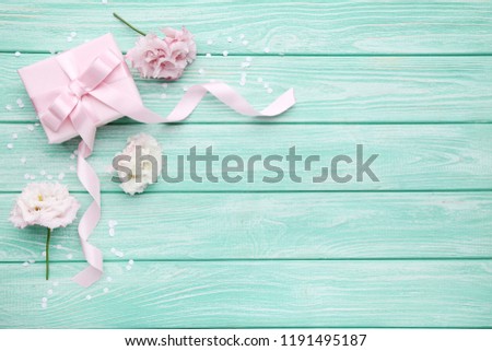 Gift box with eustoma flowers on wooden table