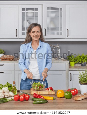 Cheerful woman preparing a salad