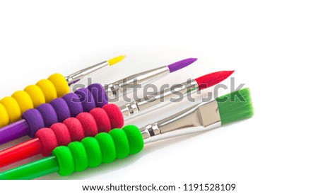 Four multi-colored various kinds of paint brushes on white background.