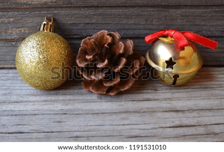 Christmas decoration with golden christmas ball,pine cone and bell on old wooden background.Winter holidays,
Merry Christmas,Happy New Year concept.Copy space.Selective focus.