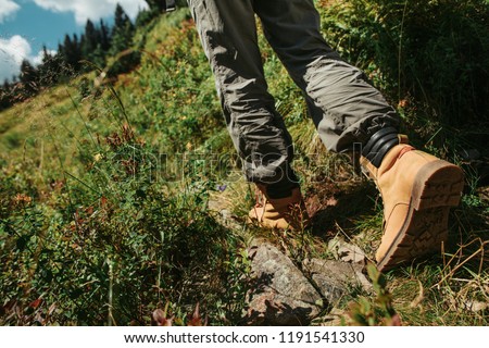 I am coming. Close up of female legs in stylish boots on the road with grass. Young lady heading to the forest Royalty-Free Stock Photo #1191541330