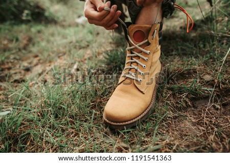 Almost ready. Close up of stylish yellow boot on female leg. Lady standing on the grass Royalty-Free Stock Photo #1191541363