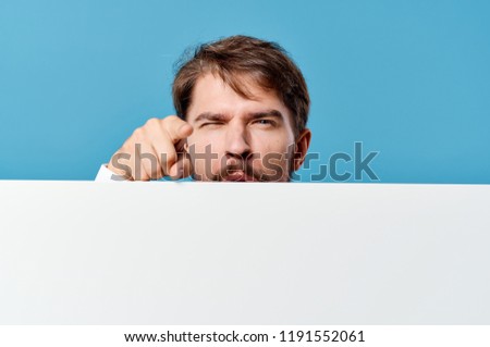 man closes behind a white sheet of paper                         