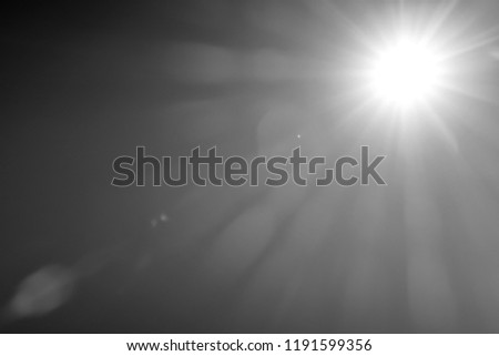 Abstract Black and white background of sun rays light effects and lens flare for over lay design. White glowing light burst on transparent background. Spotlights scene light effects. Copy space. Royalty-Free Stock Photo #1191599356