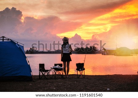 woman traveler have camping and picnic near the lake on vacation. silhouette style.