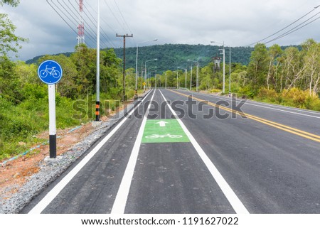 Asphalt road with white yellow lines and bicycle lenses.