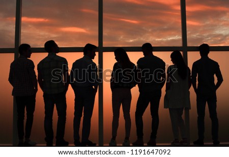 business team talking standing near a large window