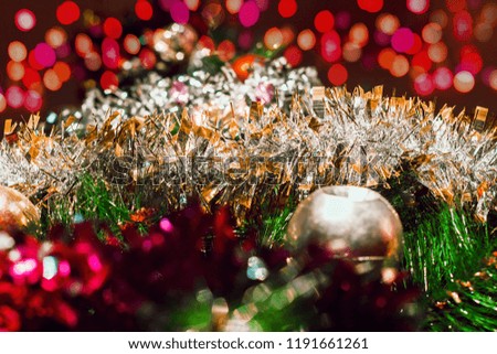 Christmas background with a bright ball and silver tinsel and multicolored lights