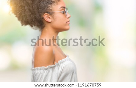 Young afro american woman wearing sunglasses over isolated background looking to side, relax profile pose with natural face with confident smile.