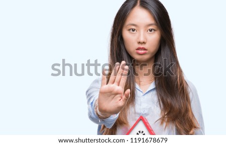 Young asian woman real state agent holding house isolated background with open hand doing stop sign with serious and confident expression, defense gesture