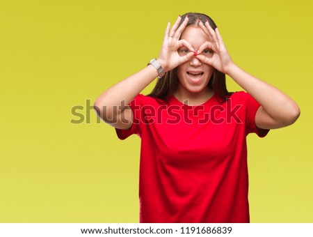 Young beautiful caucasian woman over isolated background doing ok gesture like binoculars sticking tongue out, eyes looking through fingers. Crazy expression.