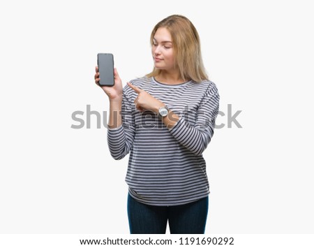 Young caucasian woman showing smartphone screen over isolated background very happy pointing with hand and finger