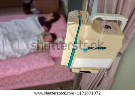 Blurry image. Asian sickness boy age 4 years old sleeping with mom on floor with the mattress. The parent of naughty patient don't want to use the bed. In order to prevent the accident of falling bed.