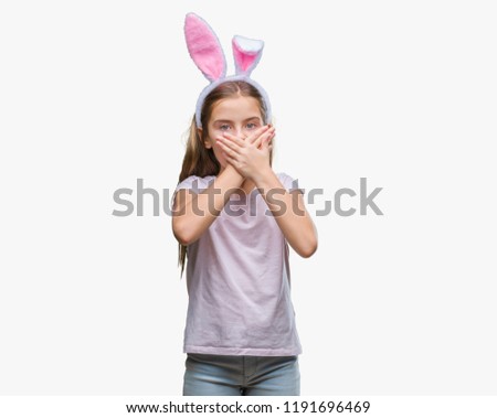Young beautiful girl wearing easter bunny ears over isolated background shocked covering mouth with hands for mistake. Secret concept.