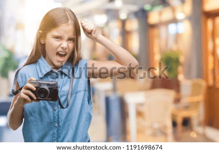 Young beautiful girl taking photos using vintage camera over isolated background annoyed and frustrated shouting with anger, crazy and yelling with raised hand, anger concept