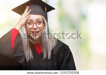 Young blonde woman wearing graduate uniform over isolated background surprised with hand on head for mistake, remember error. Forgot, bad memory concept.