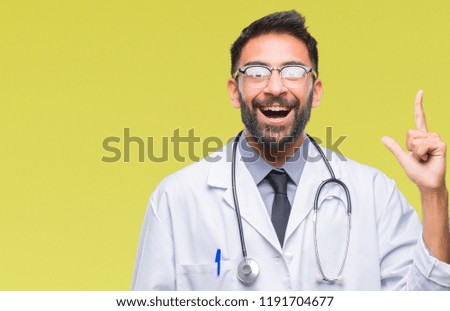 Adult hispanic doctor man over isolated background pointing finger up with successful idea. Exited and happy. Number one.
