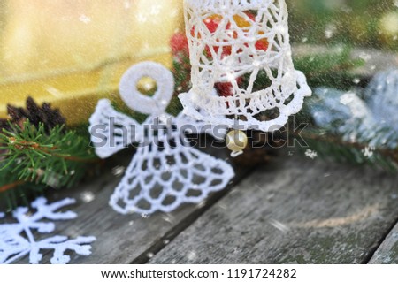 Christmas knitted bell on a festive background with the falling snow