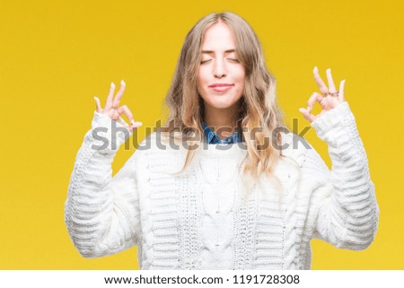 Beautiful young blonde woman wearing winter sweater over isolated background relax and smiling with eyes closed doing meditation gesture with fingers. Yoga concept.