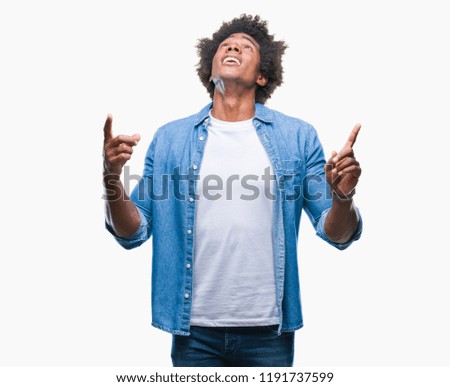 Afro american man over isolated background amazed and surprised looking up and pointing with fingers and raised arms.