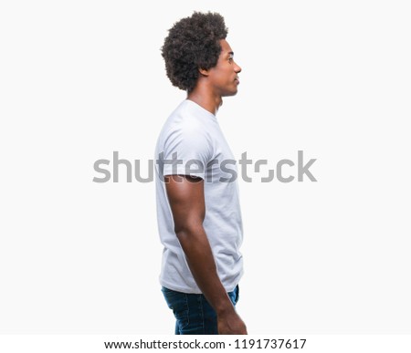 Afro american man over isolated background looking to side, relax profile pose with natural face with confident smile.