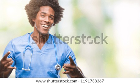 Afro american surgeon doctor man over isolated background shouting with crazy expression doing rock symbol with hands up. Music star. Heavy concept.