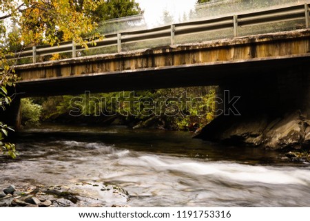 River flowing under old worn bridge