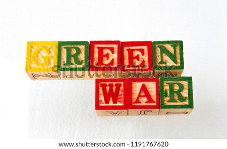 The term green war visually displayed in wooden toy blocks on a white background image with copy space in landscape format