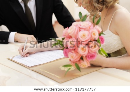Bride signing marriage license or wedding contract Royalty-Free Stock Photo #119177737