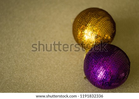 Two christmas balls for tree isolated on gold background. Violet, gold New year decorations.