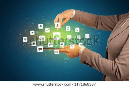 Female hand touching tablet with application icons above