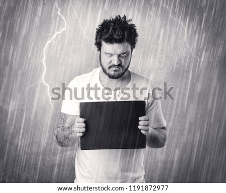 Caught gangster with rainy, grey background and black table on his hand. 