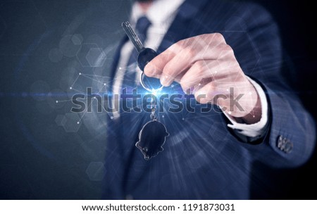 Businessman in suit holding over a key with connection concept around