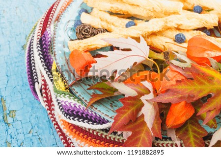 Plate with cookies and different autumn decorations, wooden background
