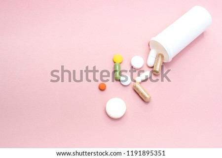 Pink medicine pills on a wood background
