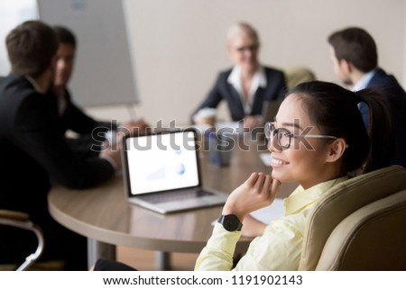 Back view of smiling Asian female employee distracted form office meeting looking in window dreaming about future achievements, happy woman not involved in briefing thinking about something