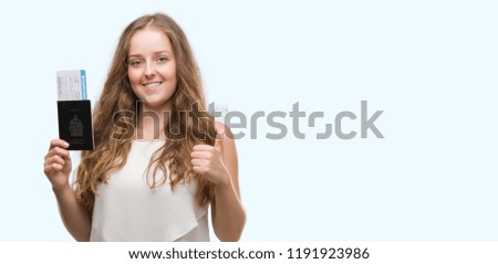 Young blonde woman holding passport of canada and boarding pass happy with big smile doing ok sign, thumb up with fingers, excellent sign